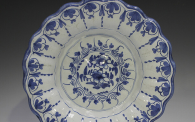 A Delft moulded dish, 18th century, painted in blue with flowers, the fluted rim with a continuous s