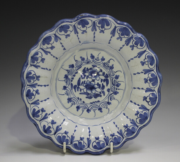 A Delft moulded dish, 18th century, painted in blue with flowers, the fluted rim with a continuous s