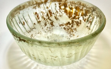 A TRANSLUCENT GLASS RIBBED BOWL.