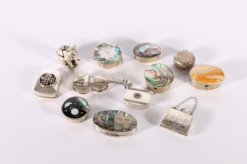 A group of twelve silver and white metal pill boxes includin...