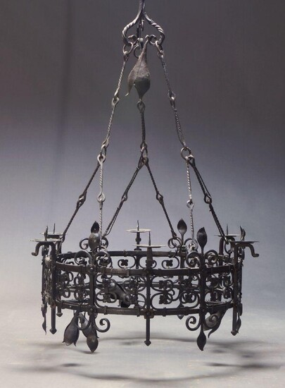 A large French wrought iron six light ceiling light, of circular form with six candles sconces and six light fittings, with Fleur de Lys and floral wrought metal motifs, approx. 135cm high, 89cm diameter