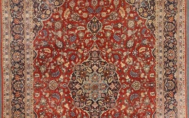 A large red ground Kashan rug, with a central medallion and blue floral boarder, 422 x 322cm