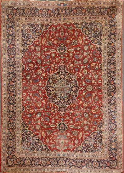 A large red ground Kashan carpet, with a central medallion and blue floral border, 422 x 322cm