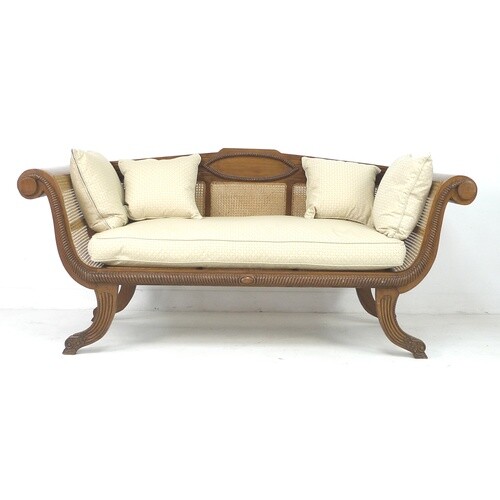 A modern tropical wood bergere settee, with carved frame and...
