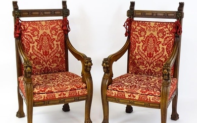 A pair of 19thC continental mahogany armchairs surmounted by corbel style reeded mounts and lions