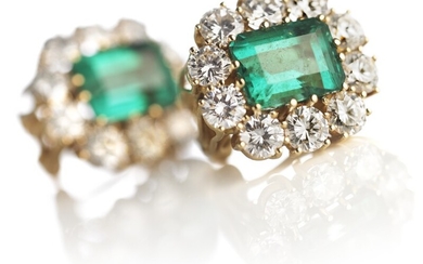A pair of emerald and diamond ear pendants each set with an emerald-cut emerald encircled by numerous brilliant-cut diamonds, mounted in 18k gold. G-H/VS. (2)