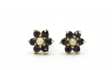 A pair of yellow metal stud earrings with flower detail set ...