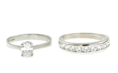 A platinum oval-shape diamond single-stone ring, together with a cubic zirconia half eternity ring.