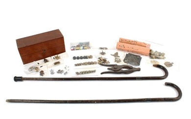 Assorted militaria to include cap badges, wire cutters, buttons and two walking sticks.