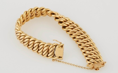 Bracelet souple en or jaune maille gourmette avec chainette de sécurité. Larg. : 1,5 cm....