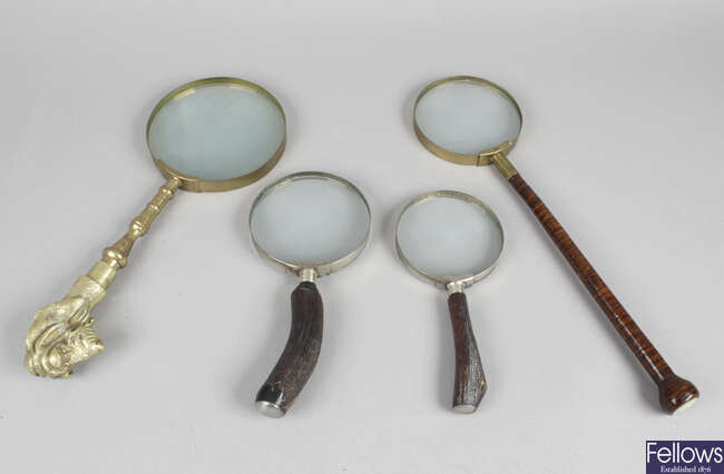 Four magnifying glasses, each with horn handles, together with an assortment of optical related items.