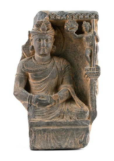 GANDHARAN RELIEF BLACK STONE PANEL Depicting a seated deity with one attendant. Fragment of a larger sculpture. Height 11".
