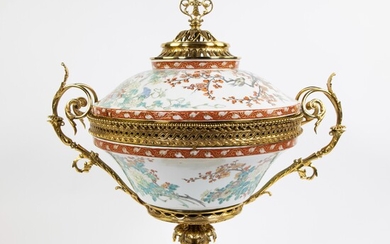 Imposing porcelain tureen/table piece on a fire-gilt base, decorated with colorful floral motifs and gilded ornaments