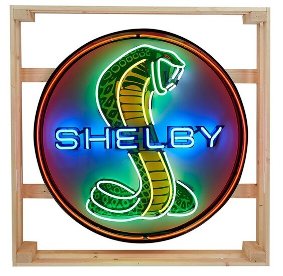 Néon Shelby Néon grand modèle en verre cristal soufflé pour la marque shelby de couleur bleu vert jaune et rouge . Structure en métal fond en tole peinte. Il est présenté dans son cadre bois d embalage original. Néon a l'éffigie du fameux preparateur...