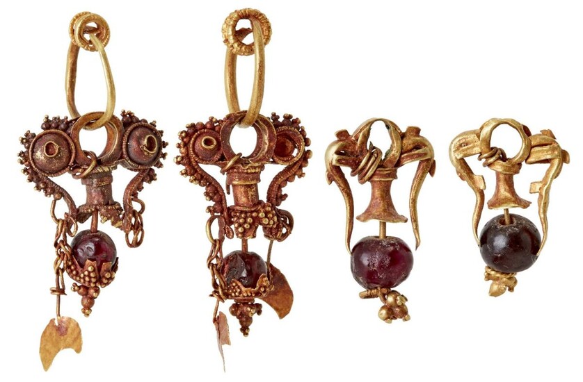 Two pairs of garnet set gold earrings in the ancient style, the first formed of three gold loops, the central one with a domed element either side with gold ball decoration, from it hangs a column element similarly decorated and with a round garnet...