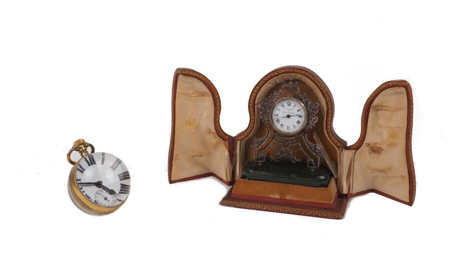 Two portable French desk clocks, one marked 'E. Drefours to their Majesties' to the enamel dial, the movement held in a metal case with glass front, supported with pierced metal frame and vine and flower decoration surmounted by an urn, to a green...