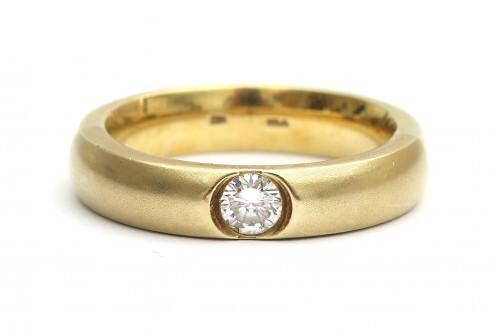 A 14 carat yellow gold diamond solitaire ring, ca. 0.25 ct. The brushed yellow gold band is tapered to the back and set at the front with a single brilliant cut diamond of ca. 0.25 ct., ca. F-G, ca. VS. Gross weight: 9.4 g.
