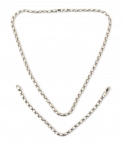 A 14 karat white gold set of a bracelet and necklace by Monzario. A 'popcorn' link necklace and matching bracelet to a lobster clasp. Gross weight: 39.5 g.
