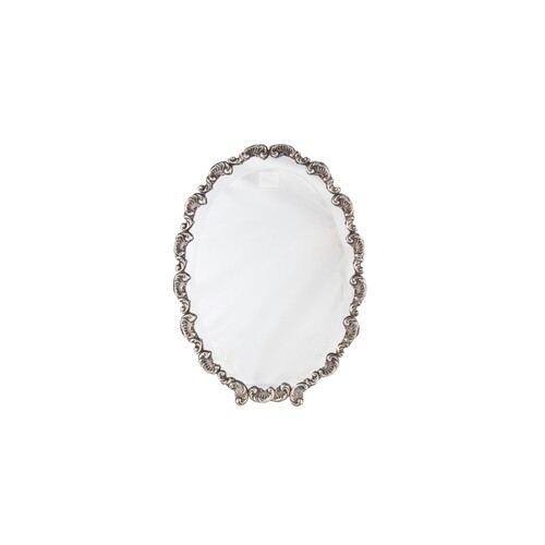 A CONTINENTAL STERLING SILVER OVAL FRAMED MIRROR, fitted bez...