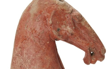 A Chinese red-painted pottery head of a horse, Han dynasty, with well defined nose bar extending to a slightly opened revealing its teeth, covered overall with a red pigment, 17cm high Provenance: Estate of the late designer Anthony Powell (1935 –...