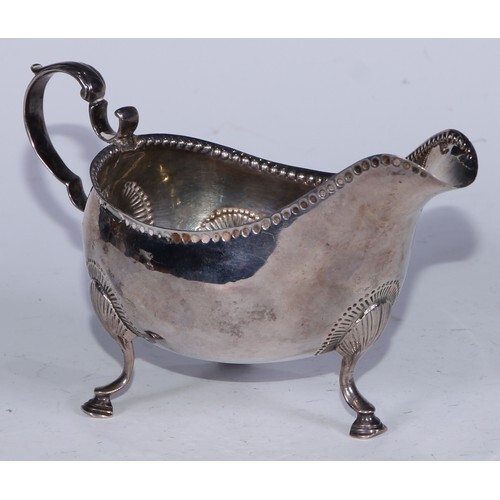 A George III Irish silver sauce boat, punch-beaded border, a...