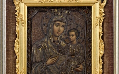 A Russian icon of Mother and Child of Smolensk, late 19th century, with chromolithographed faces, hands and feet, held within gilt heightened and studded metal oklad, in gilt frame with scrolling foliate decoration, mounted in brown plush lined and...