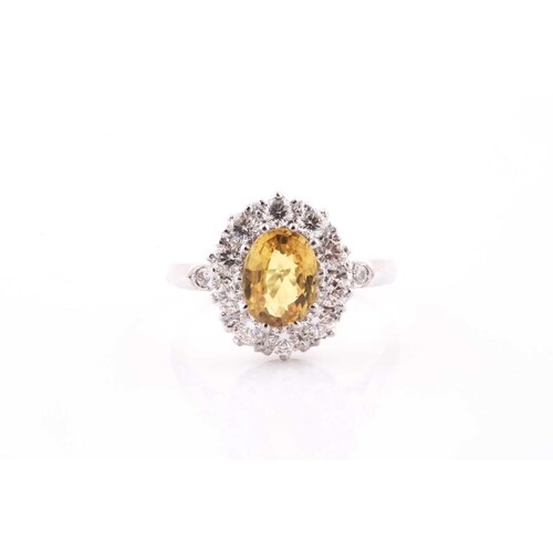 A diamond and yellow sapphire cluster ring, set with a mixed...