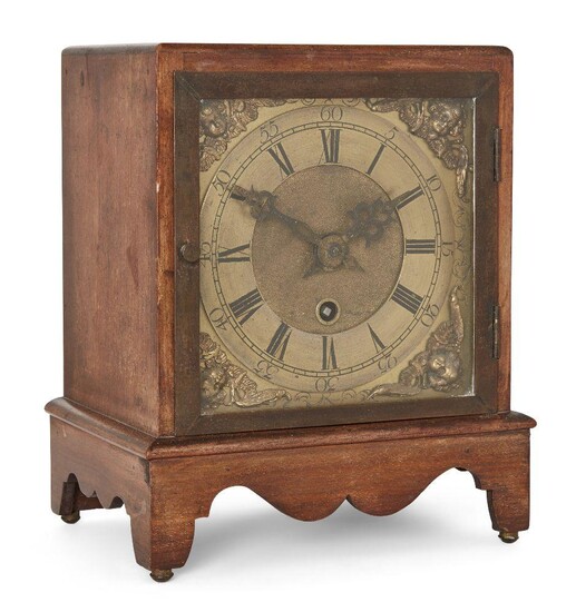 A mahogany mantel timepiece, circa 1900, the square mahogany case on bracket support with shaped apron, the brass dial with chapter ring with Roman and Arabic numerals, matted gilt dial centre and cherub spandrels, with single fusee movement case...