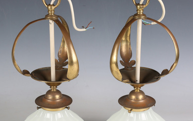 A pair of early 20th century Arts and Crafts brass ceiling hall lights with moulded glass shades and