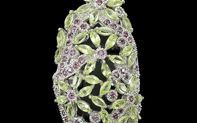 A peridot and ruby ring set with numerous navette and circular-cut peridots and rubies, mounted in rhodium plated sterling silver. Size 56. This item is subject to full VAT Full VAT On this lot, a VAT of 25% is levied on the hammer price and the...