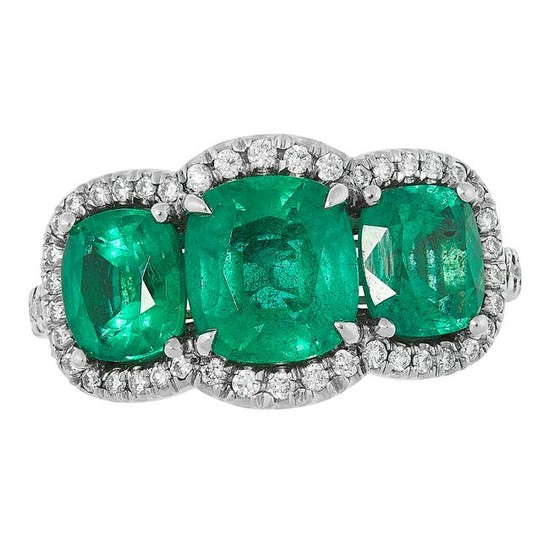 AN EMERALD AND DIAMOND RING set with three cushion cut