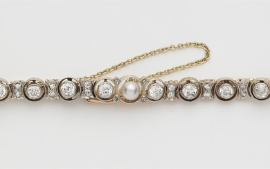 An 14k gold platinum diamond and pearl tennis bracelet.