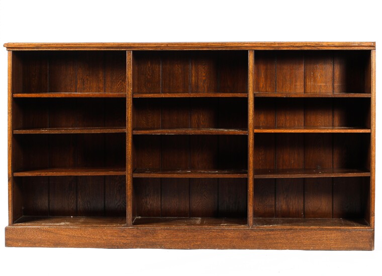 An early 20th century oak three section bookcase, with moulded top and plinth base