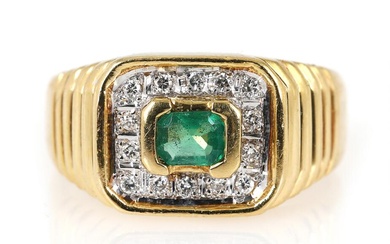 An emerald and diamond ring set with an emerald-cut emerald encircled by...
