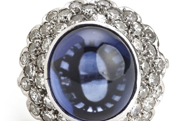 An iolite and diamond ring set with a cabochon iolite weighing app. 7.30 ct. and single-cut diamonds weighing a total of app. 1.20 ct. Circa 1950.