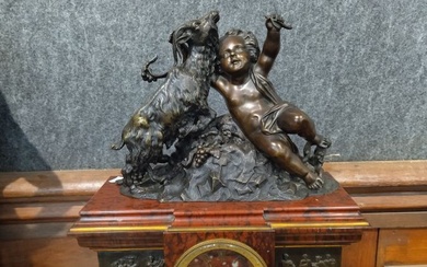 Pendule borne en marbre rouge griotte et bronze patiné "L'enfant et la chèvre", le cadran...
