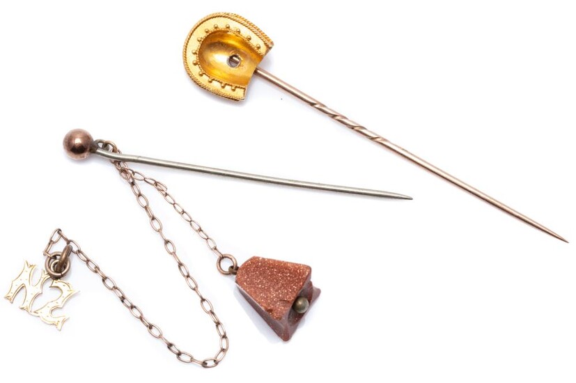 TWO ANTIQUE STICK PINS; one with 14ct gold horseshoe (missing stone) on gilt metal pin, other carved goldstone bell (chipped) and NZ...