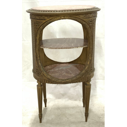 Tavolino di forma ovale in legno intagliato e dorato a ghirlande fogliate, tre piani in marmo, gambe rastremate. Secolo XIX...