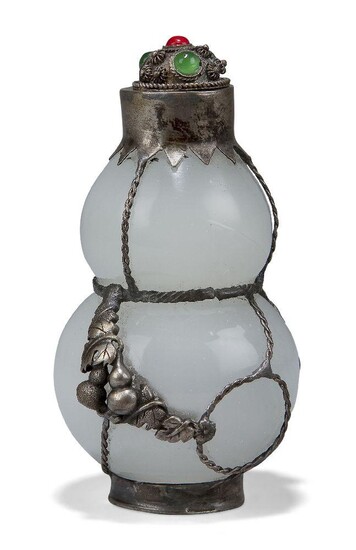 A Chinese white metal mounted Peking glass snuff bottle, 20th century, of gourd form, the glass of opaque quality encased in white metal, the cover set with coral and green hardstone cabochons, 9cm high