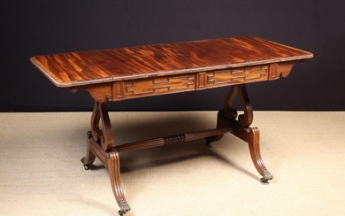 A Fine Regency Style Mahogany Sofa Table. The flame figured top with rounded drop flaps either end o