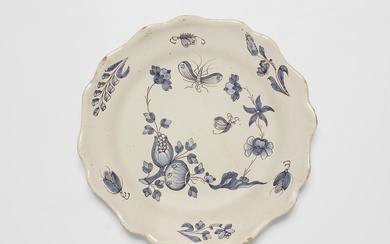 A French faience plate with "fleurs contournées" and insect motifs