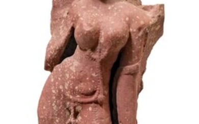 A MOTTLED RED SANDSTONE FIGURE OF A STANDING DEVI.