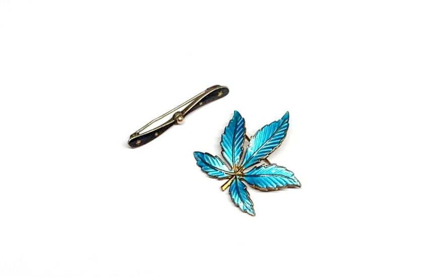 A Norwegian enamelled silver leaf brooch and a white metal propellor brooch.