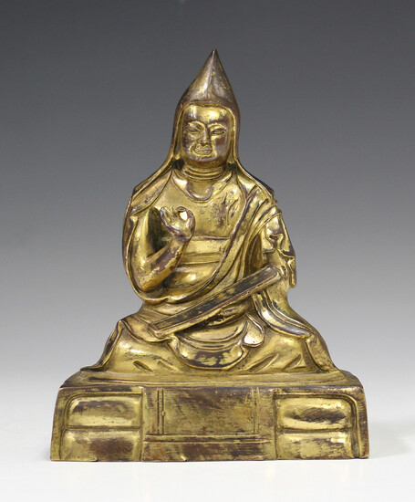 A Sino-Tibetan gilt bronze figure of a lama, probably late Qing/20th century, modelled seated wearin