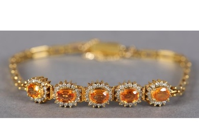 A YELLOW SAPPHIRE AND DIAMOND BRACELET, the oval faceted sap...
