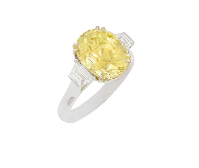 A YELLOW SAPPHIRE AND DIAMOND RING The oval-shaped...