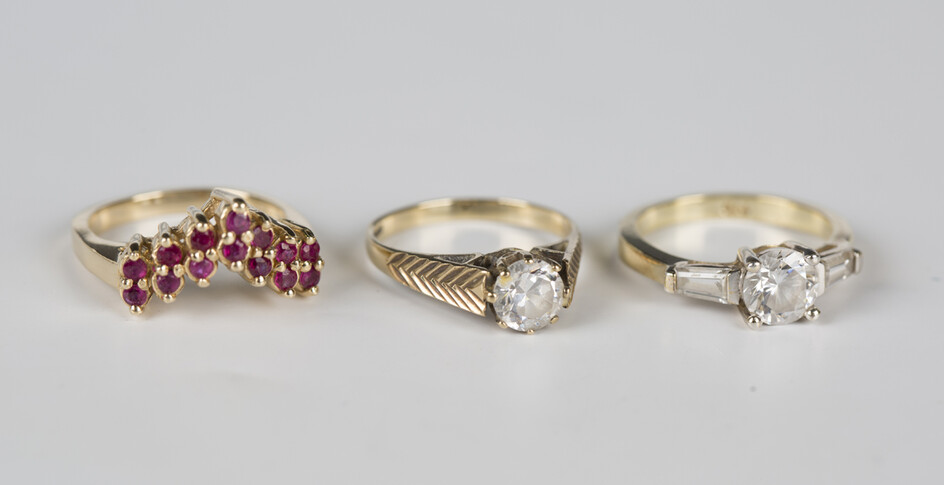 A gold ring, mounted with two rows of circular cut rubies in a V-shaped design, detailed '14K