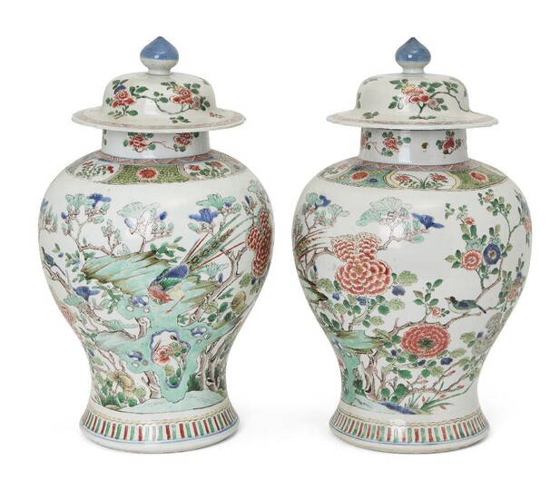 A large pair of Chinese jars and covers, 19th century, painted in famille verte enamels with peonies, exotic birds, and chrysanthemum issuing from rockwork in a continuous landscape, underglaze blue double circle to base, 43cm high Provenance...