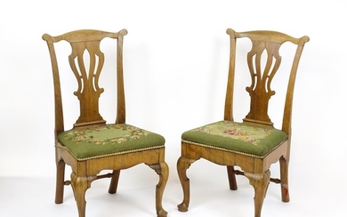 A pair of George II walnut side chairs with shaped top rails...