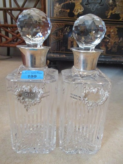 A pair of Mappin & Webb silver coloured and cut glass decant...